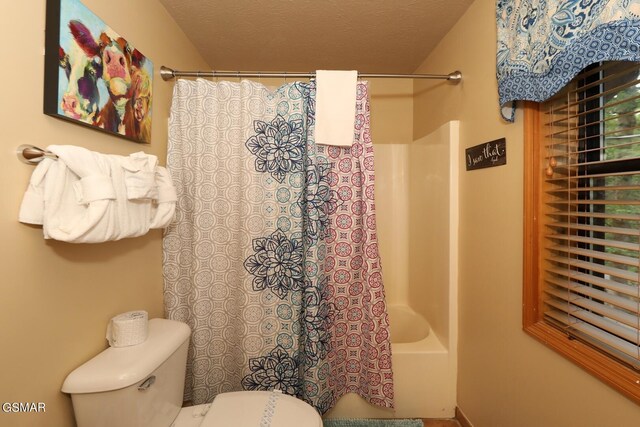 bathroom featuring shower / bathtub combination with curtain and toilet