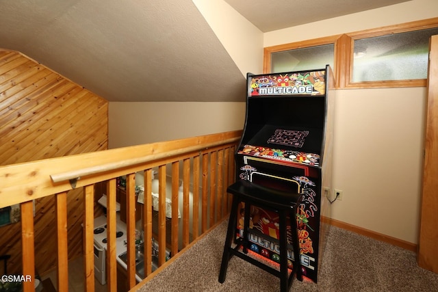 game room featuring wood walls, carpet, and vaulted ceiling