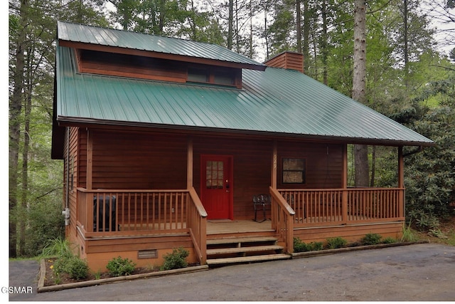 log-style house featuring covered porch