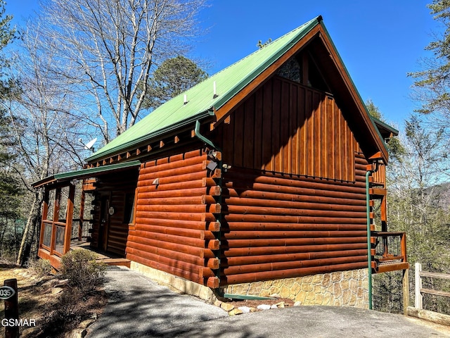 view of side of home with log exterior and metal roof