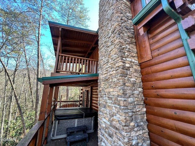 view of property exterior with a balcony and faux log siding