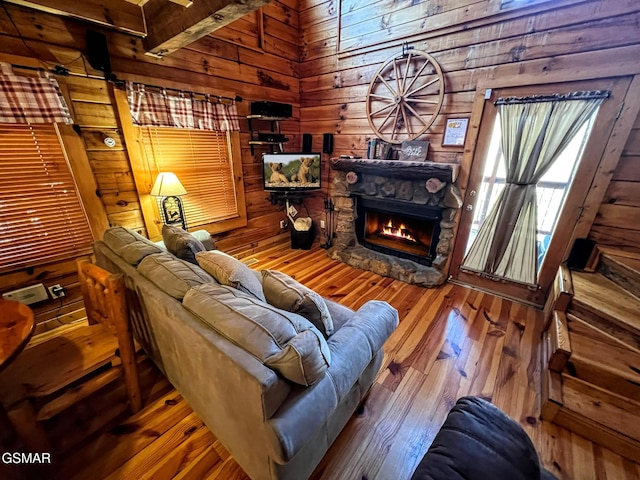 living room with wooden walls, hardwood / wood-style floors, and a fireplace