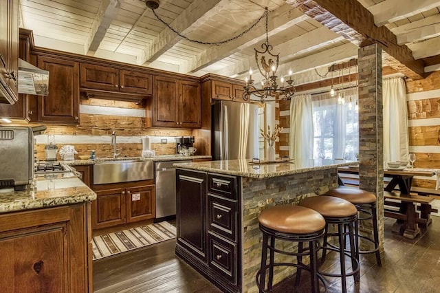 kitchen featuring dark wood-style flooring, beamed ceiling, wood ceiling, a sink, and stainless steel appliances