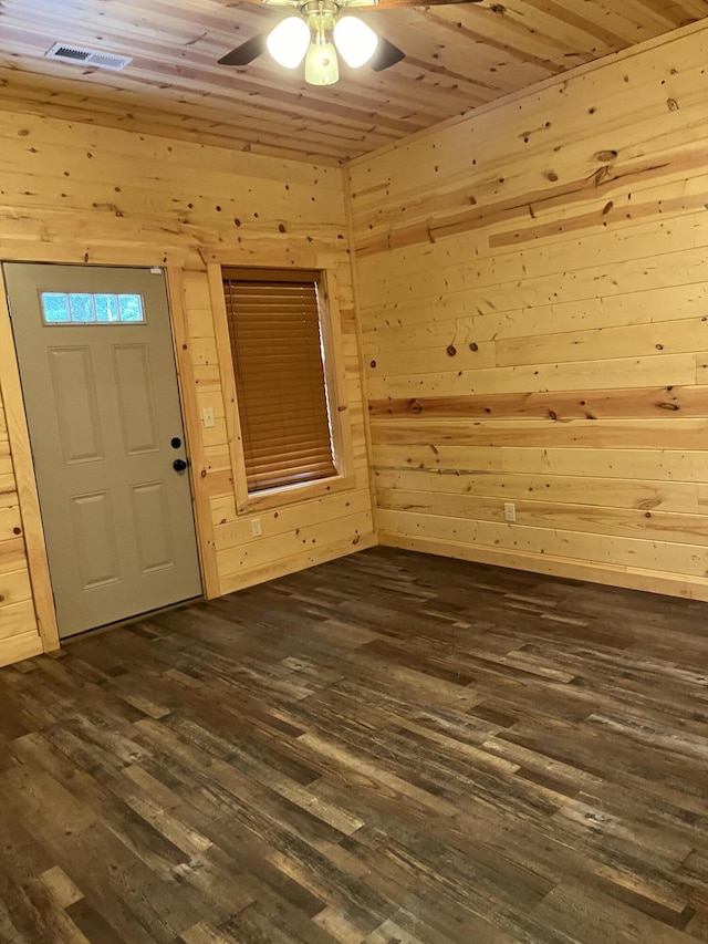 entrance foyer with wood walls, dark wood-type flooring, and wood ceiling