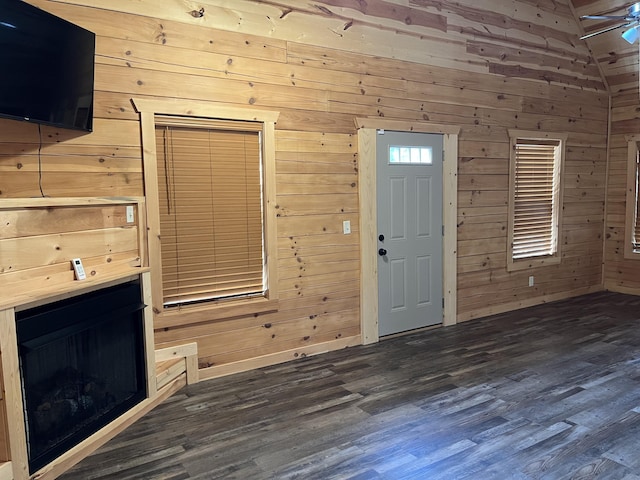 foyer entrance featuring wood walls and vaulted ceiling