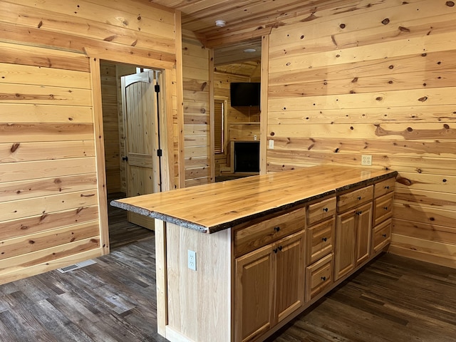 kitchen featuring dark wood-type flooring, wood counters, wood walls, a kitchen island, and wood ceiling