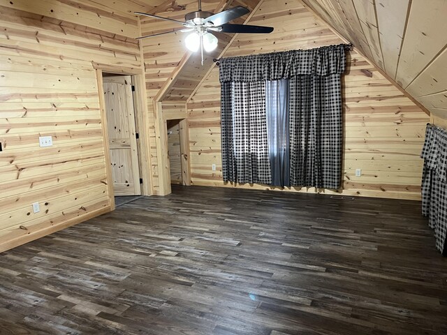 additional living space with dark hardwood / wood-style floors, ceiling fan, lofted ceiling, and wooden walls