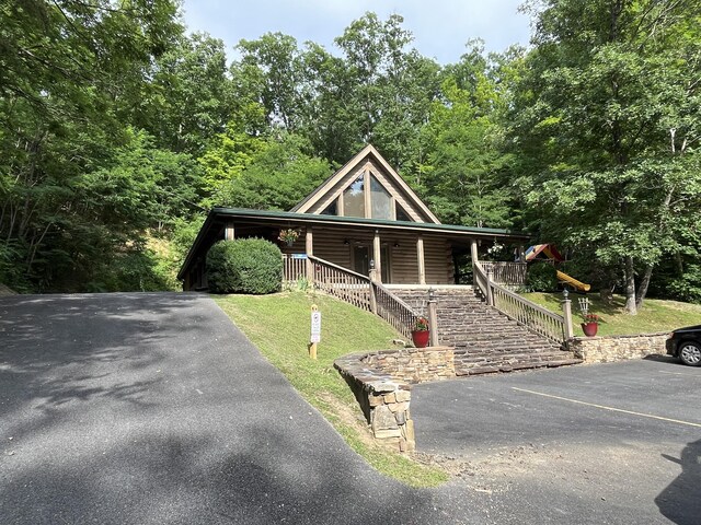 log cabin with a front yard and a porch