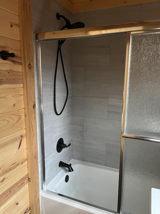 bathroom featuring combined bath / shower with glass door