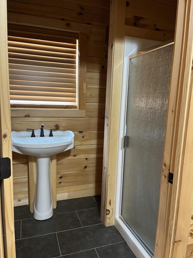 bathroom with tile patterned flooring, an enclosed shower, and wooden walls