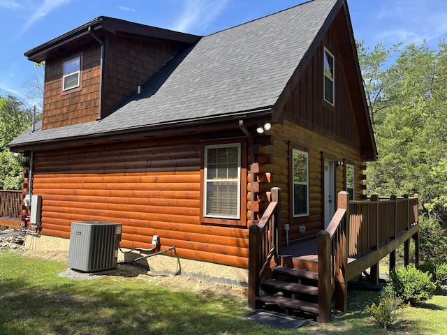 rear view of house with a wooden deck, a lawn, and central air condition unit