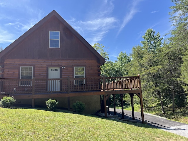 view of side of home with a wooden deck and a yard