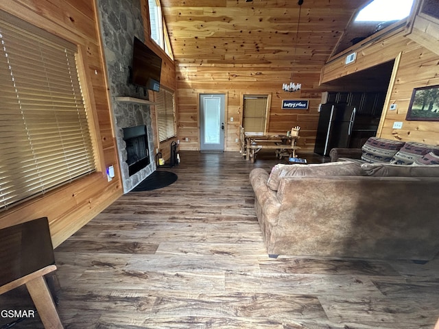 living room with wooden ceiling, high vaulted ceiling, a stone fireplace, wooden walls, and wood-type flooring