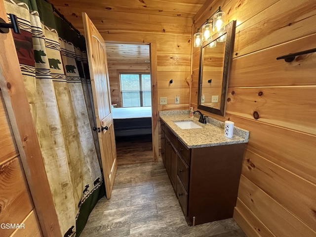 bathroom featuring vanity, wood walls, and wooden ceiling