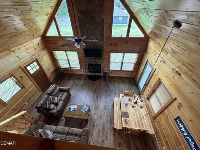 unfurnished living room with a fireplace, a high ceiling, ceiling fan, and a healthy amount of sunlight