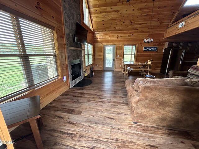 living room featuring a fireplace, wooden walls, dark wood-type flooring, and wood ceiling