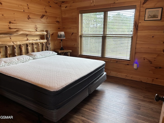 bedroom featuring dark hardwood / wood-style floors and wood walls