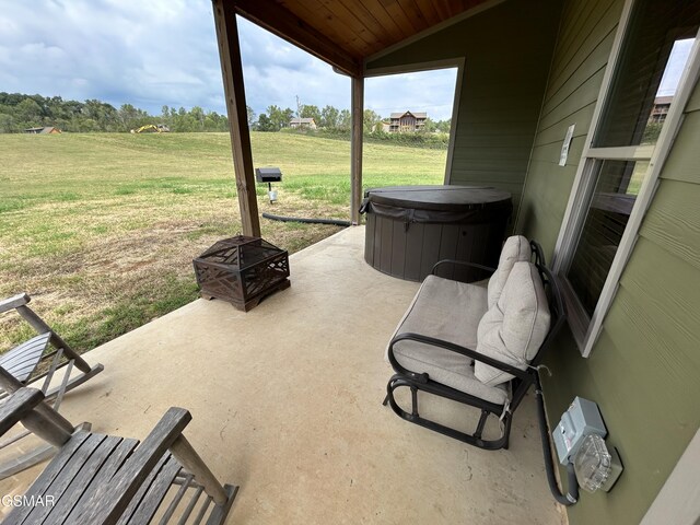 view of patio / terrace featuring a hot tub and an outdoor fire pit