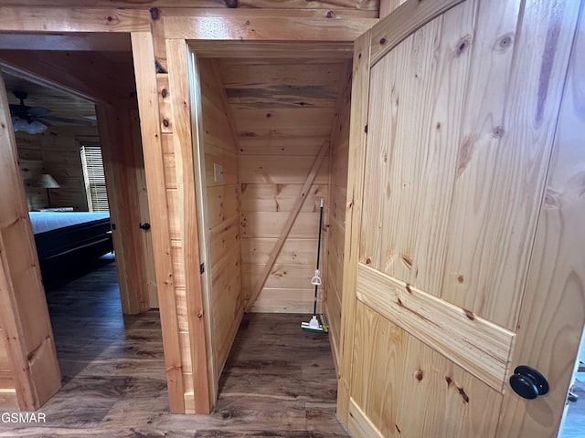 hallway featuring wood ceiling, dark wood-type flooring, and wooden walls