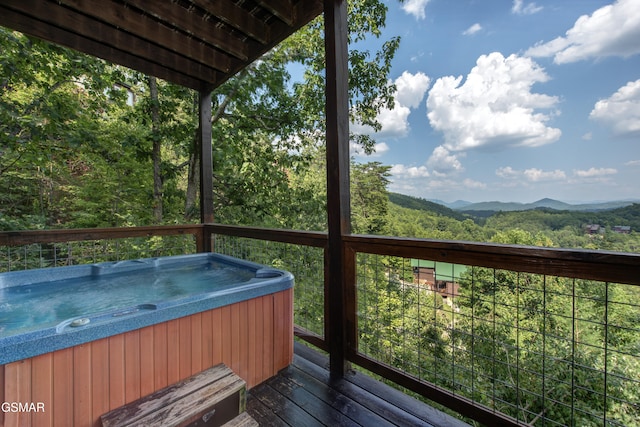 wooden terrace with a hot tub and a mountain view