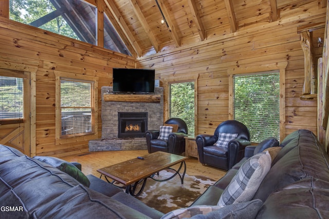 living room featuring beam ceiling, wood walls, hardwood / wood-style flooring, and a fireplace