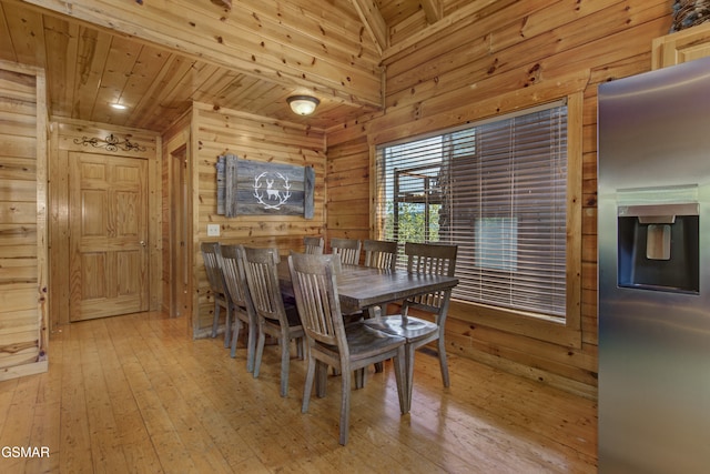 dining space featuring wooden ceiling, wooden walls, and light hardwood / wood-style flooring