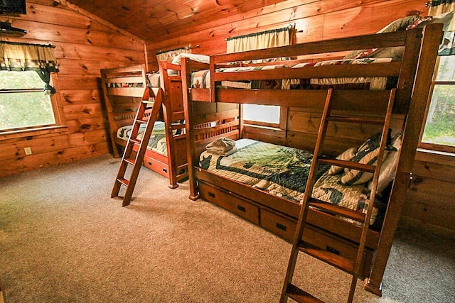 bedroom with wooden ceiling, carpet floors, wooden walls, and vaulted ceiling