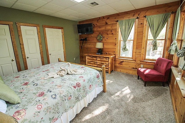 bedroom featuring carpet flooring and wooden walls