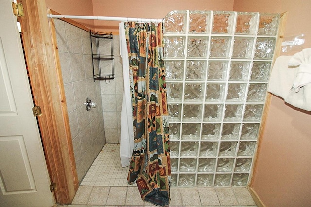 bathroom with a shower with curtain and tile patterned flooring