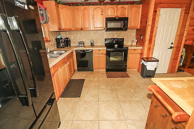 kitchen with black appliances, light tile patterned floors, sink, and tasteful backsplash