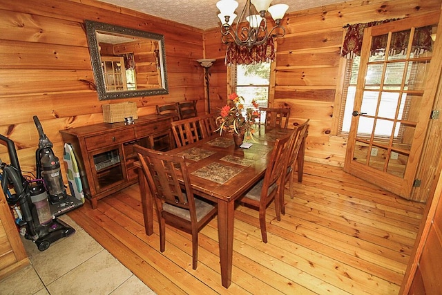 dining room with light hardwood / wood-style floors, a textured ceiling, and a chandelier