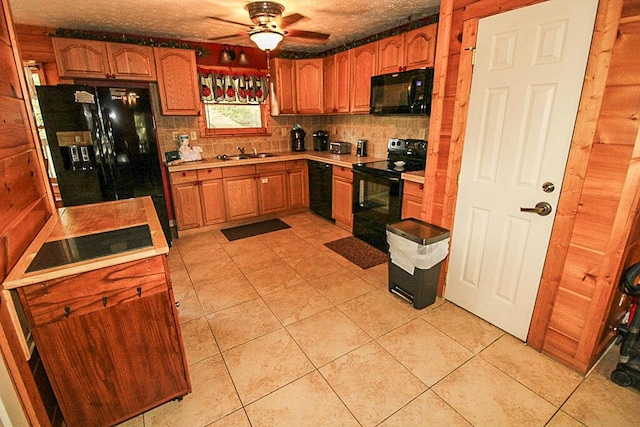 kitchen with tasteful backsplash, ceiling fan, sink, black appliances, and light tile patterned floors