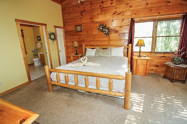 bedroom with connected bathroom, carpet floors, and lofted ceiling