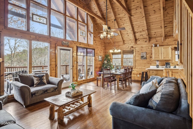 living room featuring high vaulted ceiling, wooden walls, beamed ceiling, wood ceiling, and light wood-type flooring