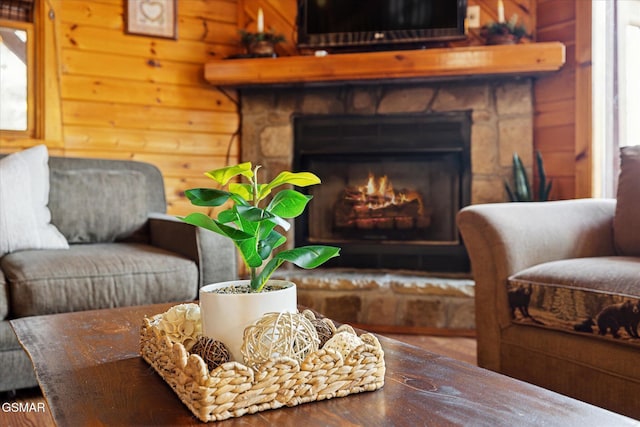 sitting room with log walls and a stone fireplace