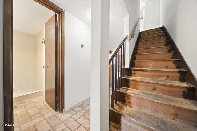 260 Roaring Fork Rd Unit 217, Gatlinburg, TN 37738 - stairway featuring stone tile floors and a textured ceiling