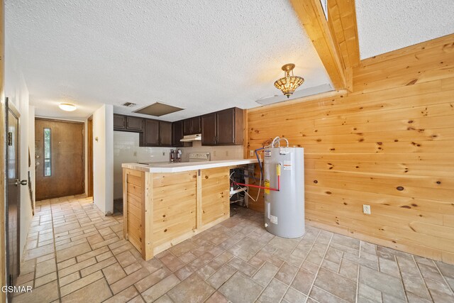 260 Roaring Fork Rd Unit 217, Gatlinburg, TN 37738 - kitchen featuring light countertops, water heater, wood walls, dark brown cabinets, and a peninsula