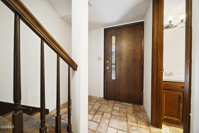 260 Roaring Fork Rd Unit 217, Gatlinburg, TN 37738 - foyer entrance featuring stairway, a textured ceiling, and stone tile floors