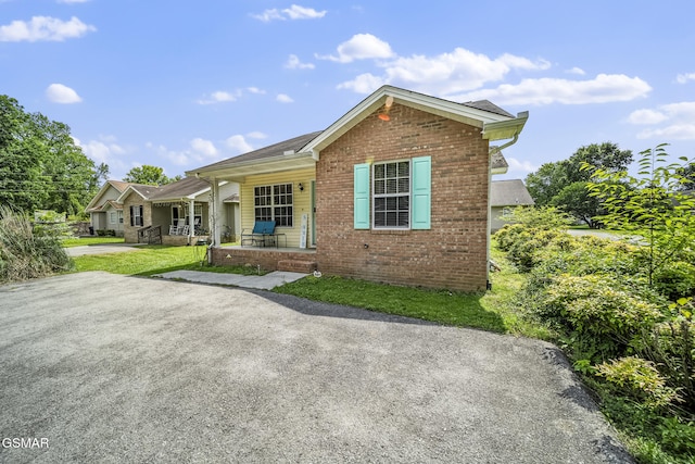 1733 Snapp Rd, Sevierville, TN 37862 - view of front of house featuring covered porch, brick siding, and a front yard