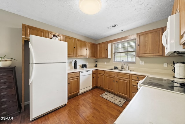 1733 Snapp Rd, Sevierville, TN 37862 - kitchen with white appliances, a sink, light wood-style flooring, a textured ceiling, and light countertops