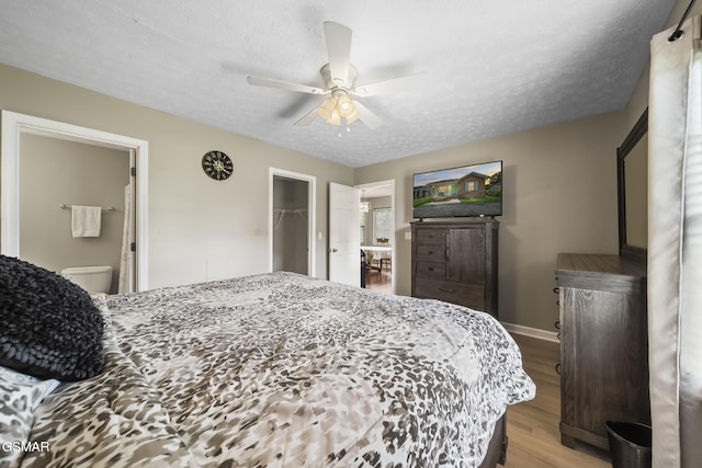 1733 Snapp Rd, Sevierville, TN 37862 - bedroom featuring wood finished floors, a textured ceiling, ceiling fan, baseboards, and ensuite bathroom