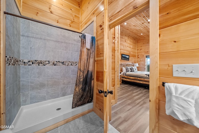 bathroom featuring wooden walls and walk in shower