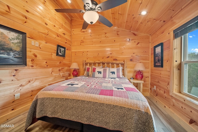 bedroom featuring lofted ceiling, ceiling fan, wood walls, and wood ceiling