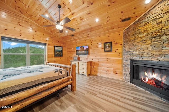 bedroom featuring light hardwood / wood-style flooring, ceiling fan, wooden ceiling, and wood walls