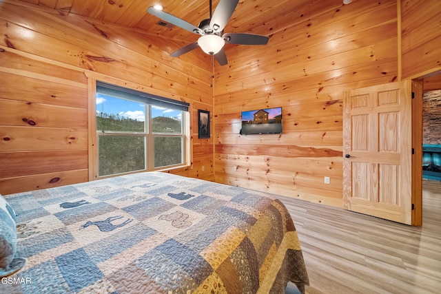 bedroom featuring vaulted ceiling, ceiling fan, wooden walls, hardwood / wood-style flooring, and wooden ceiling