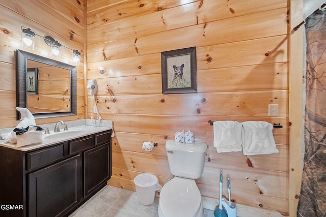 bathroom with tile patterned flooring, vanity, toilet, and wooden walls