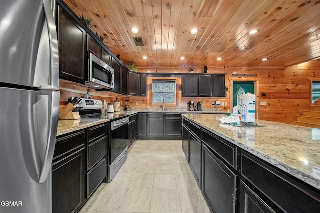 kitchen with wood walls, sink, wooden ceiling, and appliances with stainless steel finishes