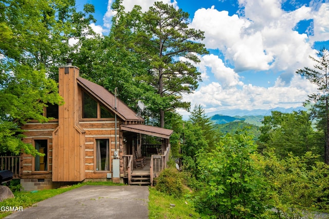 view of front facade with a mountain view and a chimney