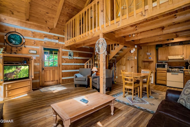 living area featuring wood walls, wood finished floors, wood ceiling, stairway, and beam ceiling