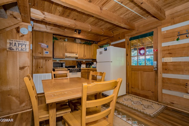 dining area featuring beam ceiling, visible vents, wooden walls, wood finished floors, and wooden ceiling